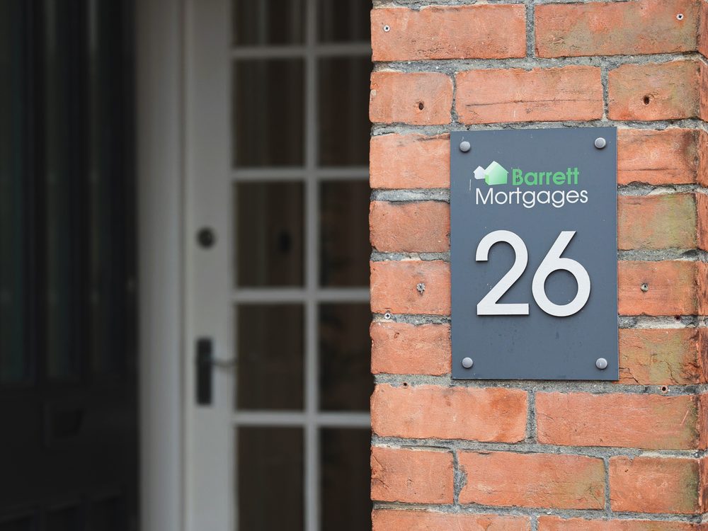The Barrett Mortgages number 26 sign on the brick wall beside the office entrance