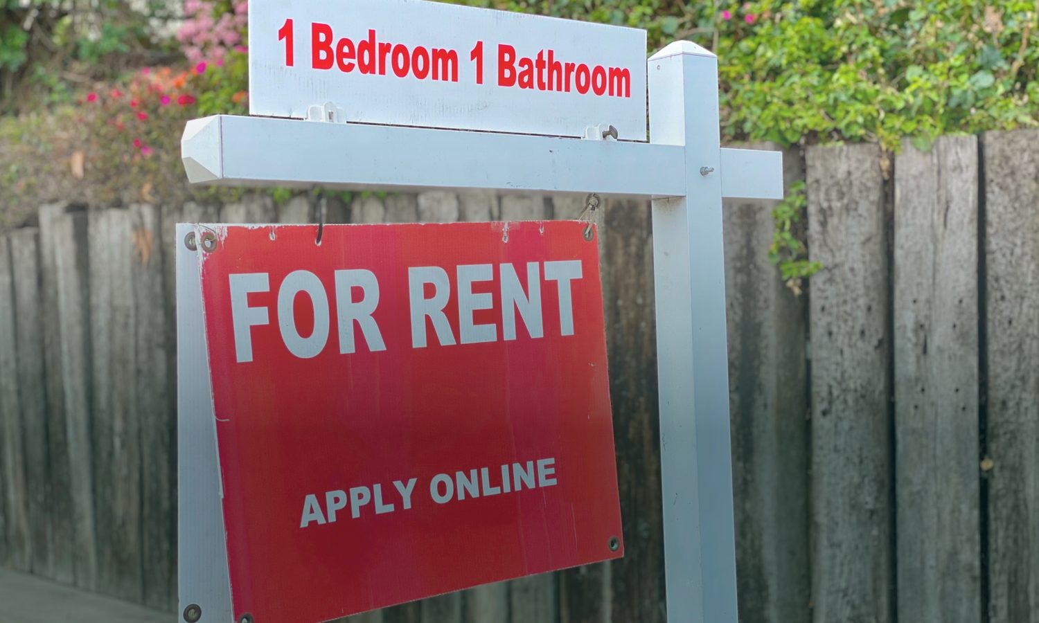 A ‘For Rent’ board outside a property, advertising one bedroom and one bathroom.
