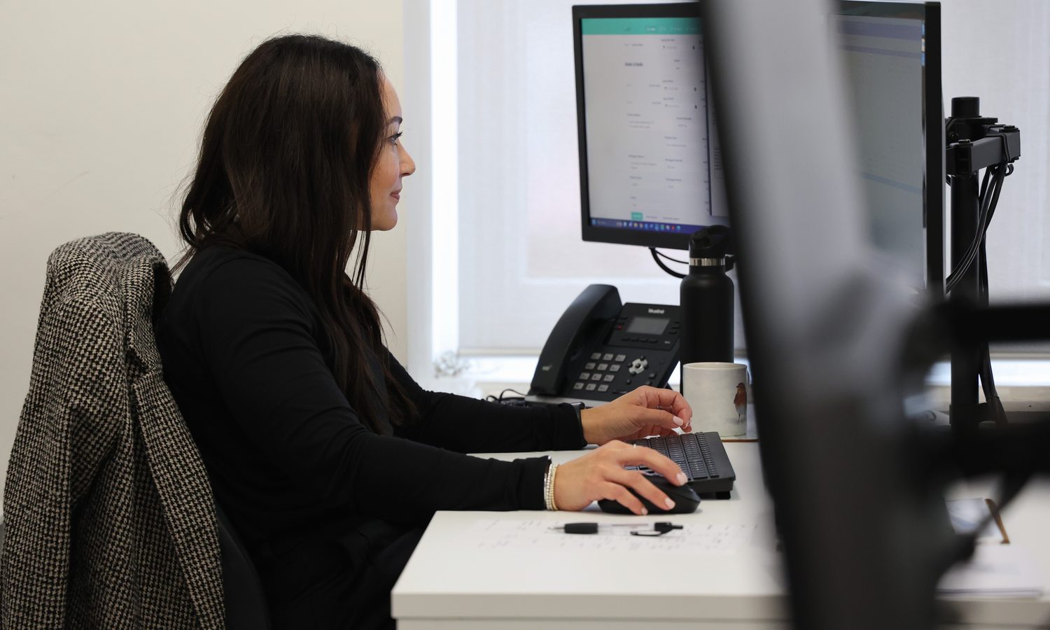 A member of the Barrett Mortgages team at her desk, with a telephone beside her.