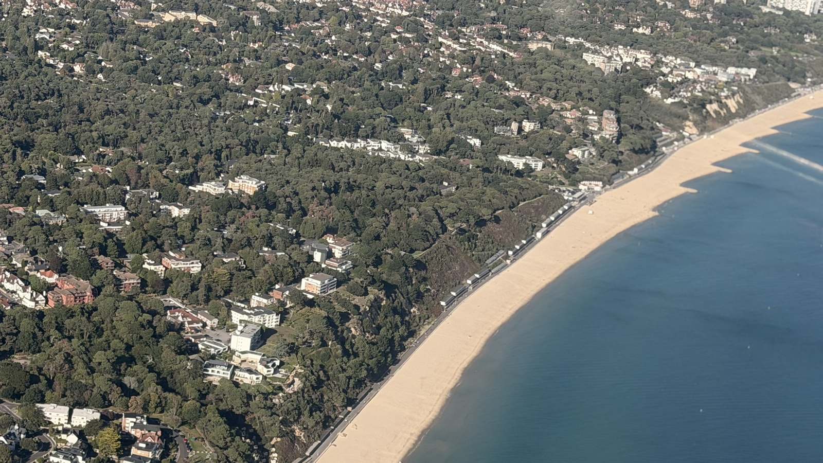 Aerial view of Branksome Chine beach and the houses set in the pines at Branksome Park, Poole