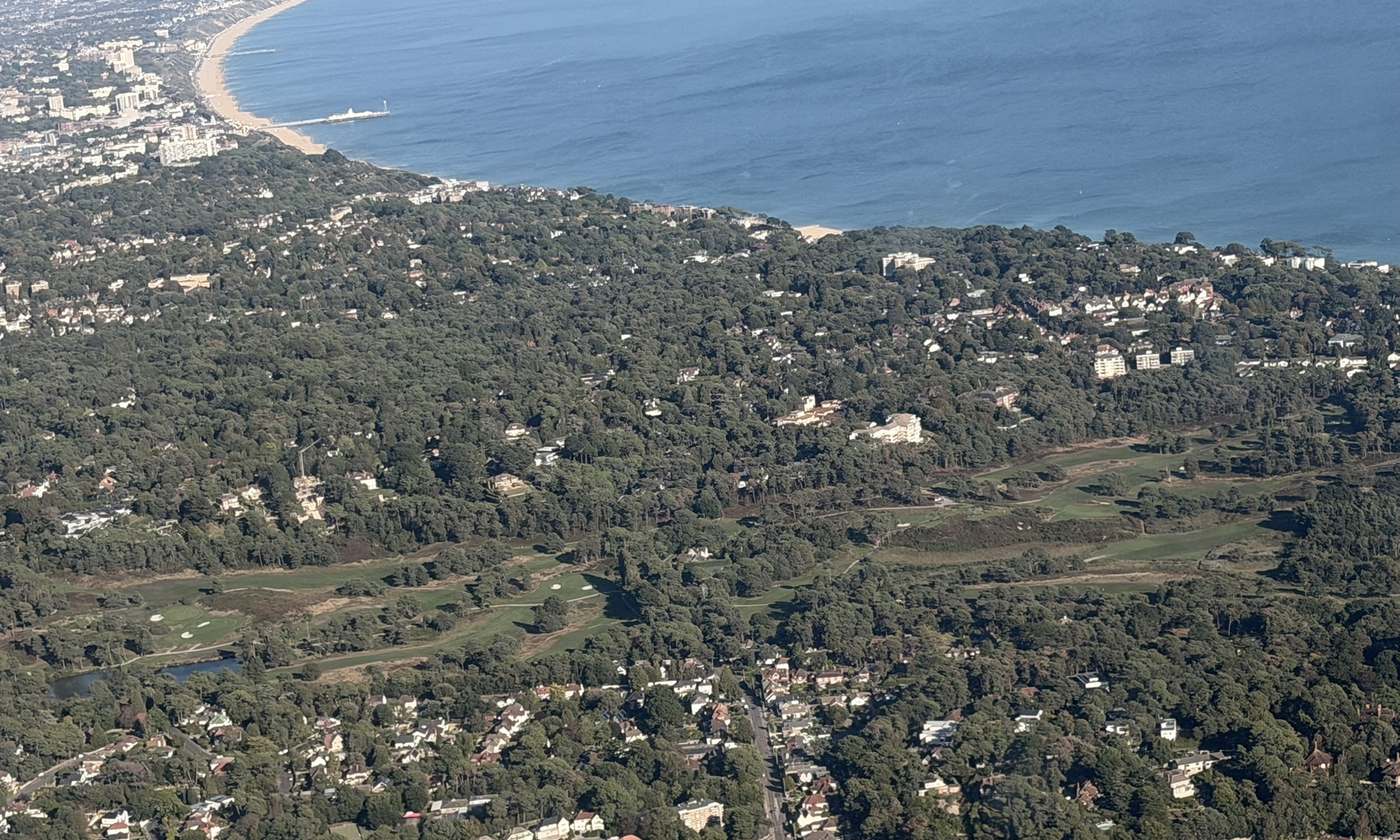 Aerial view of Canford Cliffs and Branksome Park, Poole, with the golf course and the coast beyond